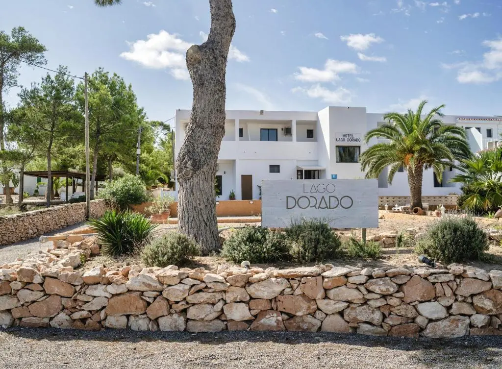 Entrée de l'Hotel Lago Dorado avec son enseigne et un muret en pierre