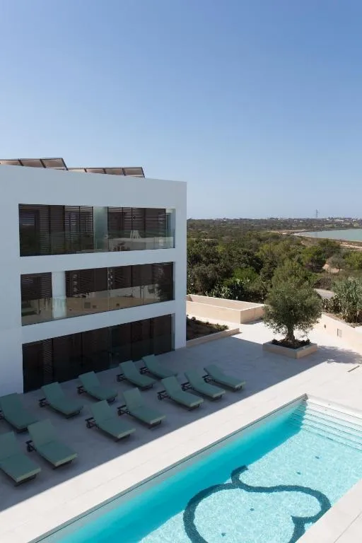 Edificio moderno y piscina de Sa Pedrera Suites & Spa
