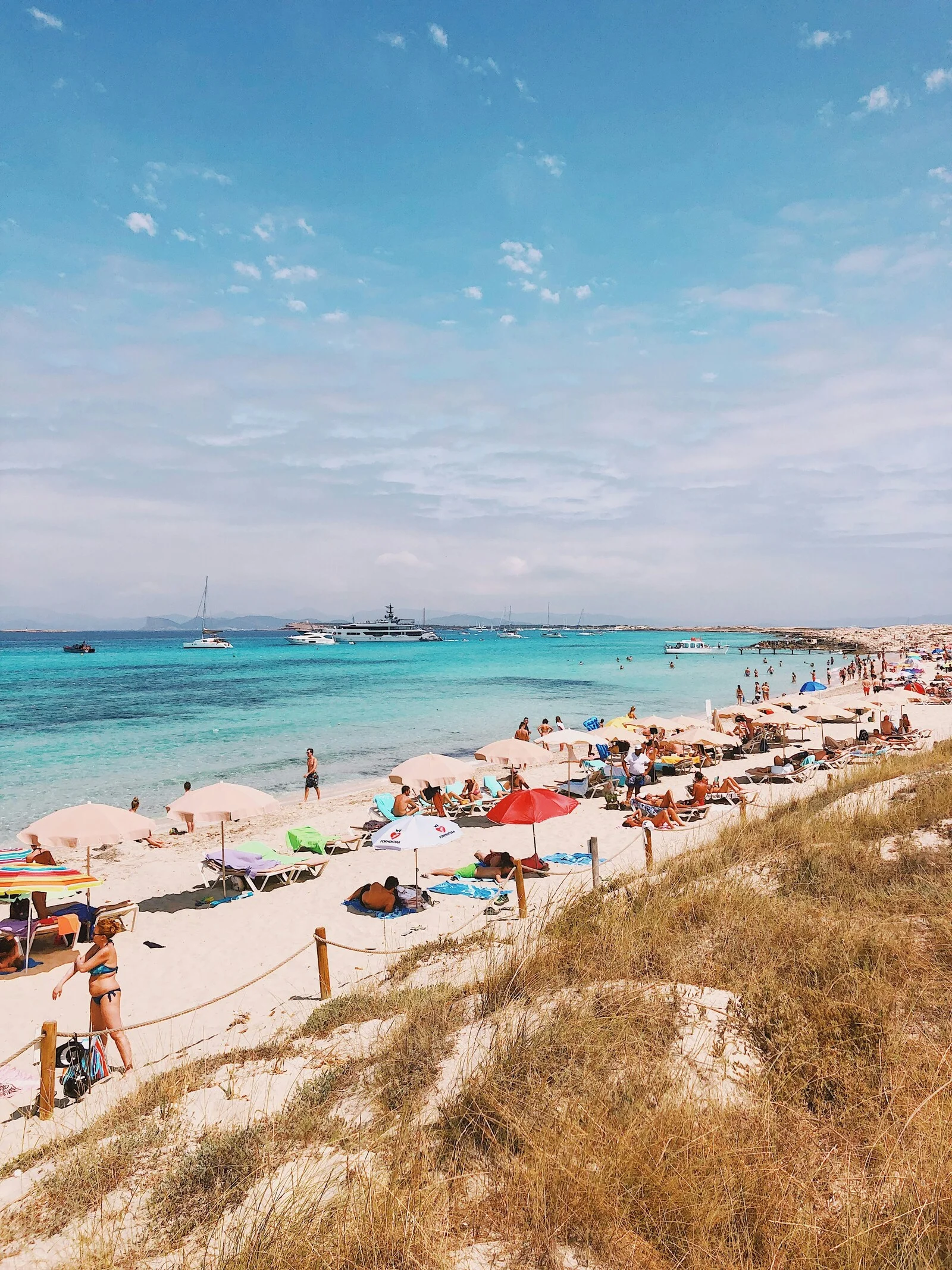 Transats et parasols de Ses Illetes face aux yachts au mouillage, Formentera
