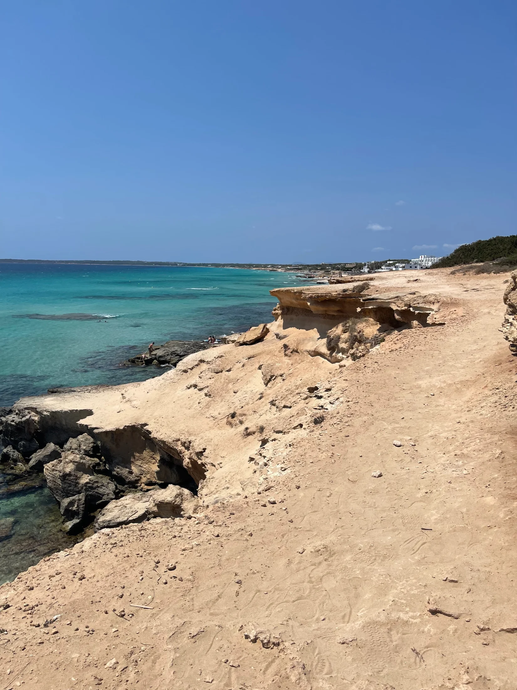 Sentier de grès en haut de falaise et eau turquoise sur la côte du Caló des Mort à Formentera