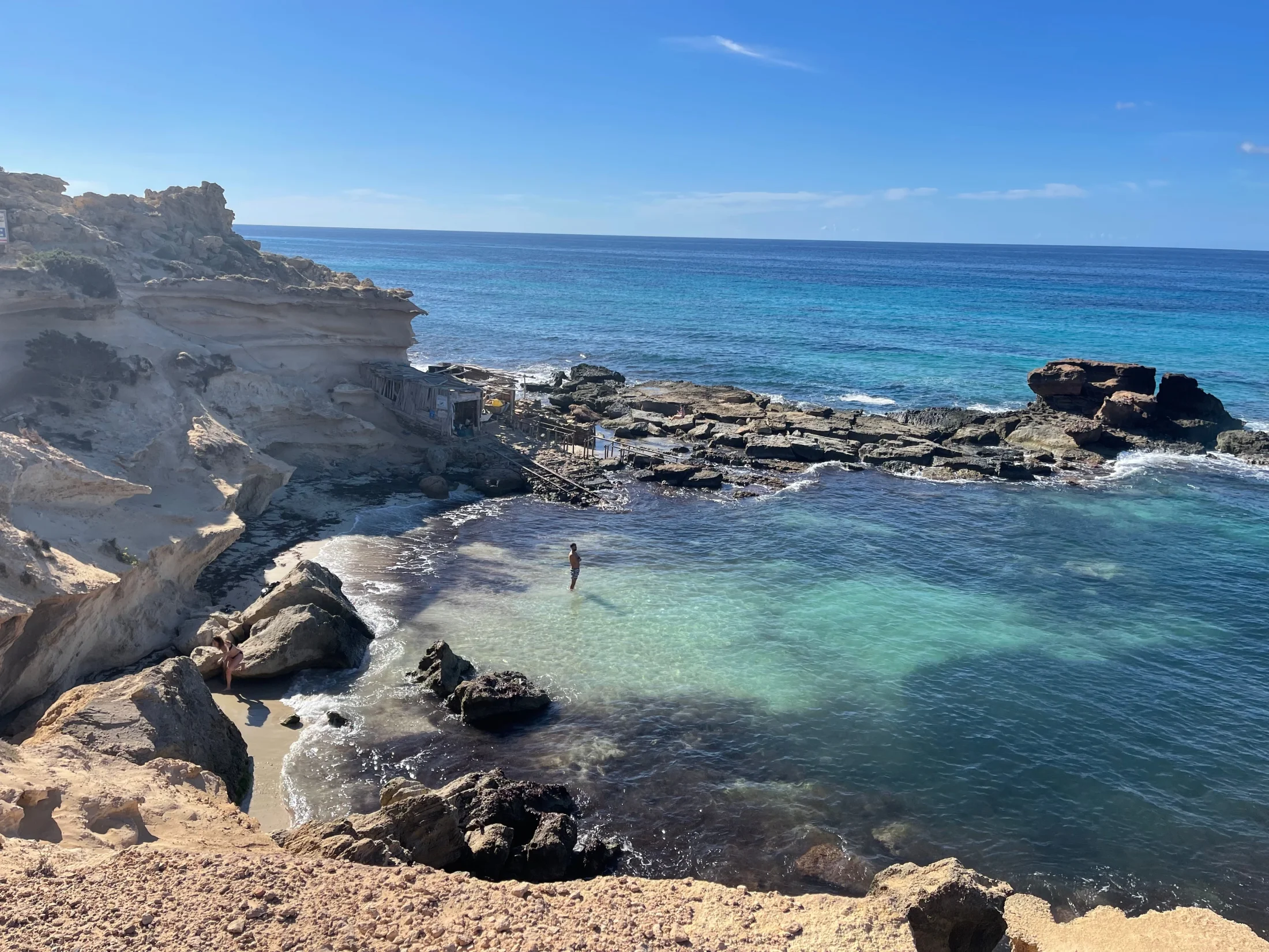 Crique du Caló des Mort à Formentera, eau transparente, falaise de grès et cabane de pêcheur