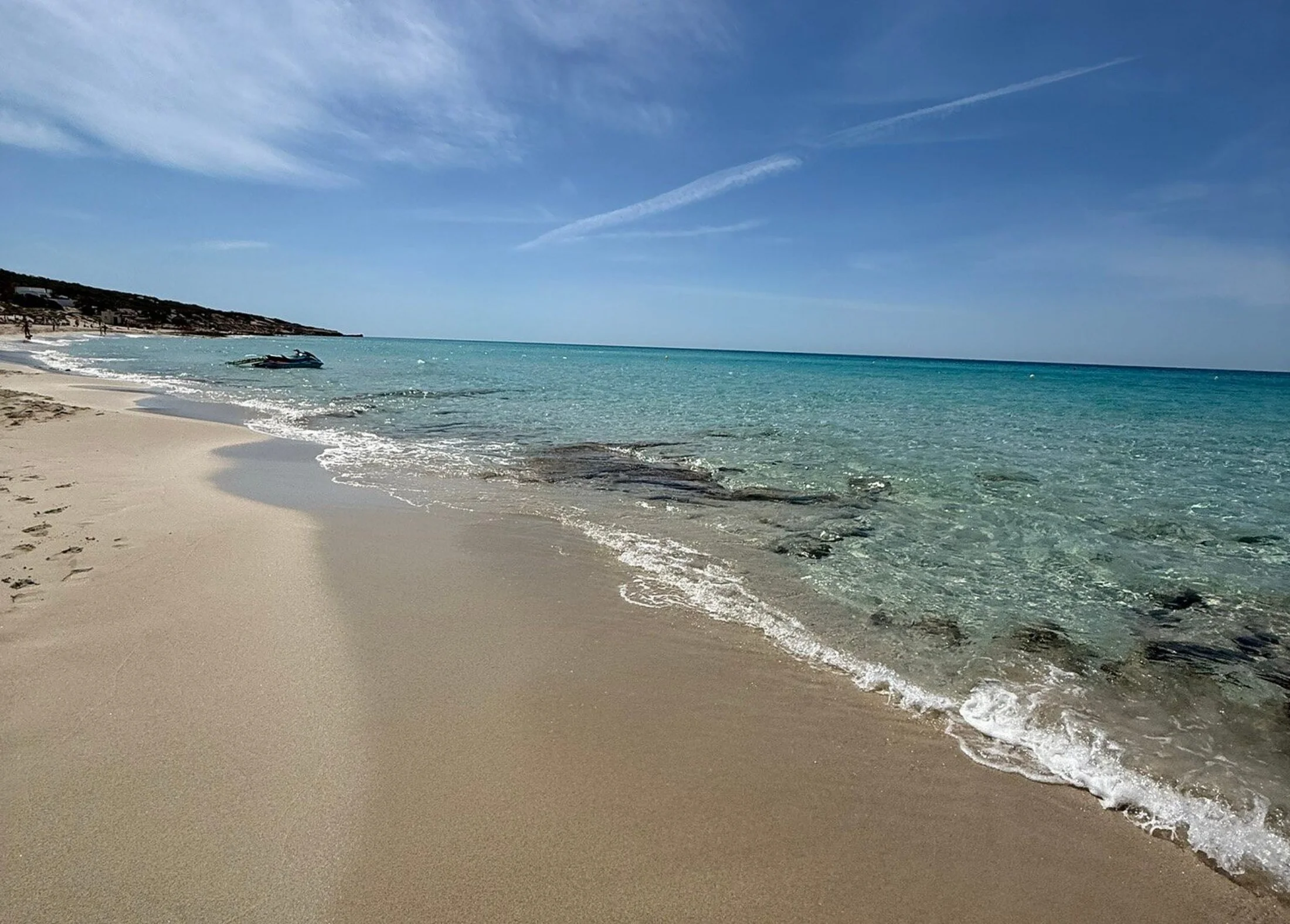 Courbe de sable et eau turquoise le long de la plage d'Es Arenals à Formentera