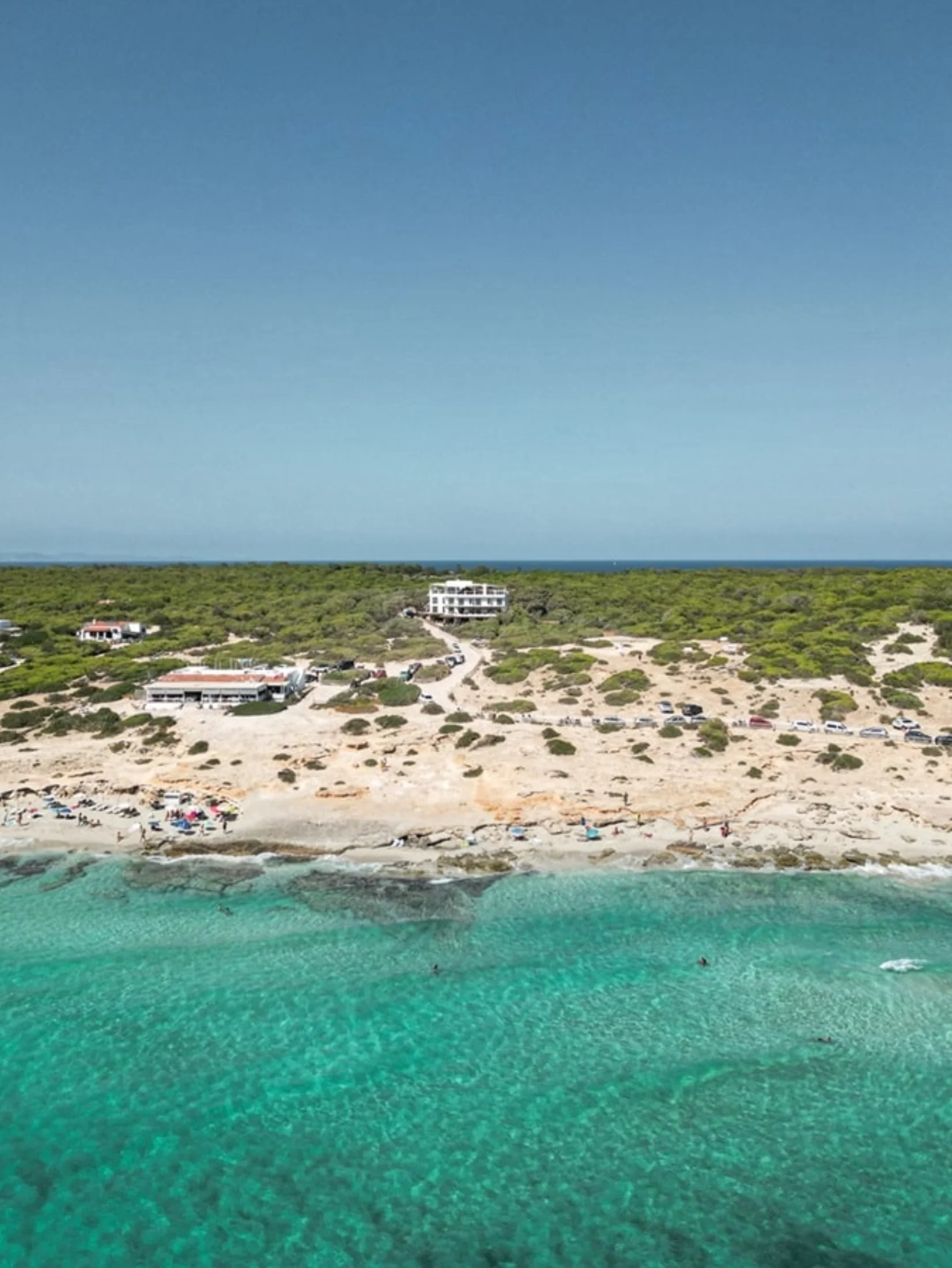 Vue aérienne d'Es Arenals à Formentera avec hôtel, parking et eau émeraude