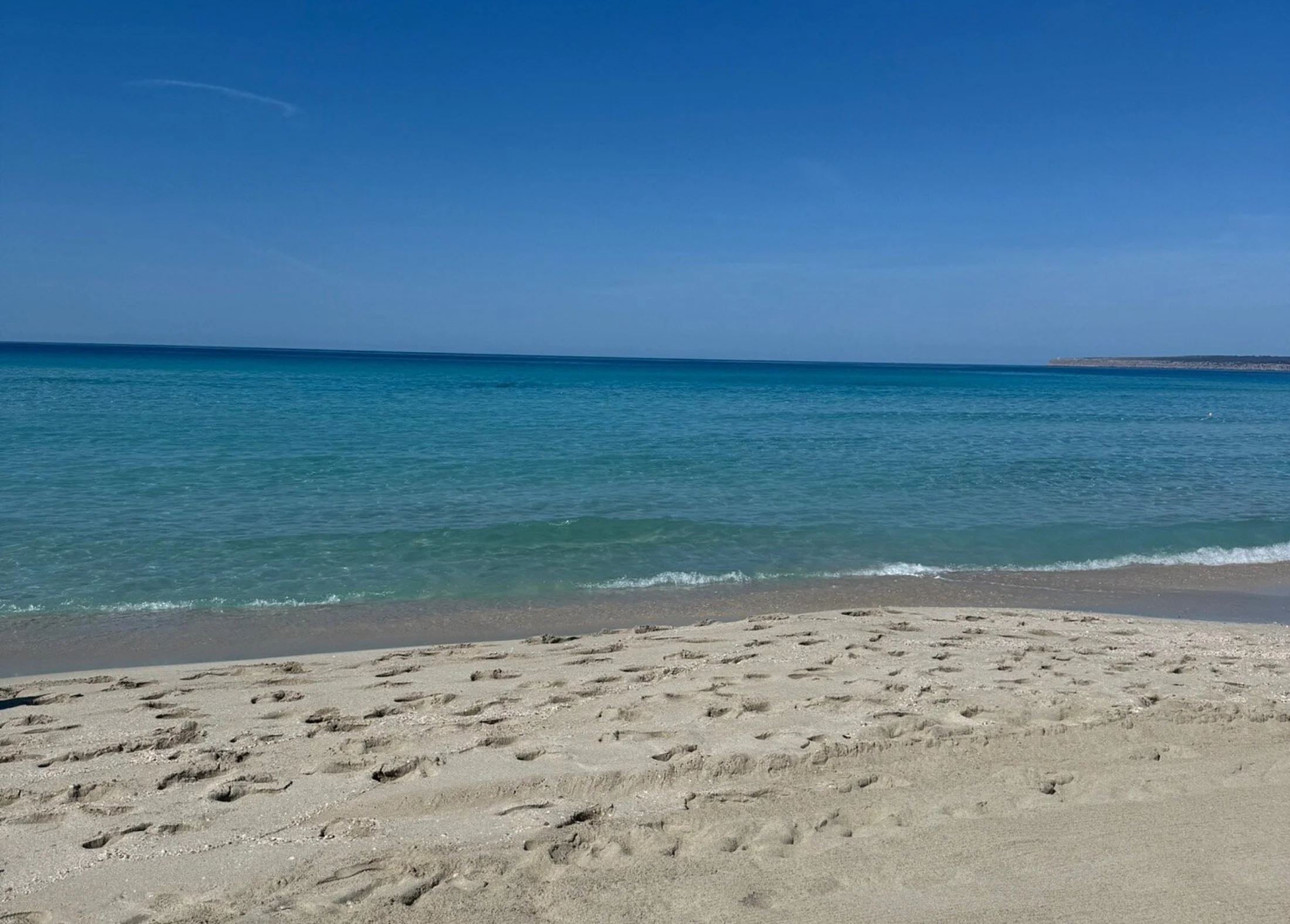 Plage déserte d'Es Arenals à Formentera, sable clair et dégradé de bleus