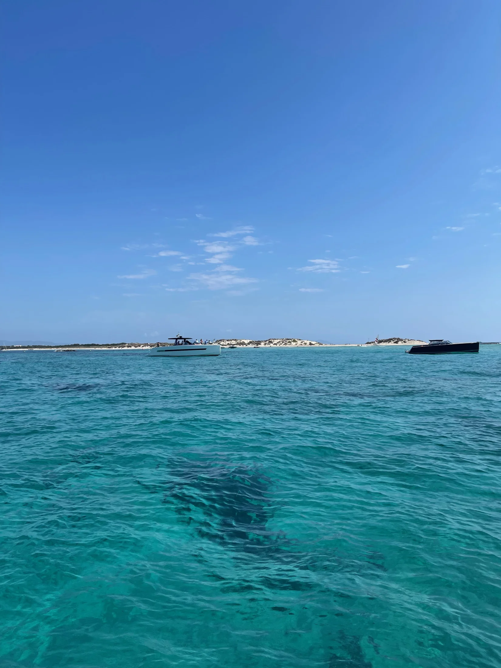 Mer turquoise et bateaux ancrés devant Platja de Llevant à Formentera