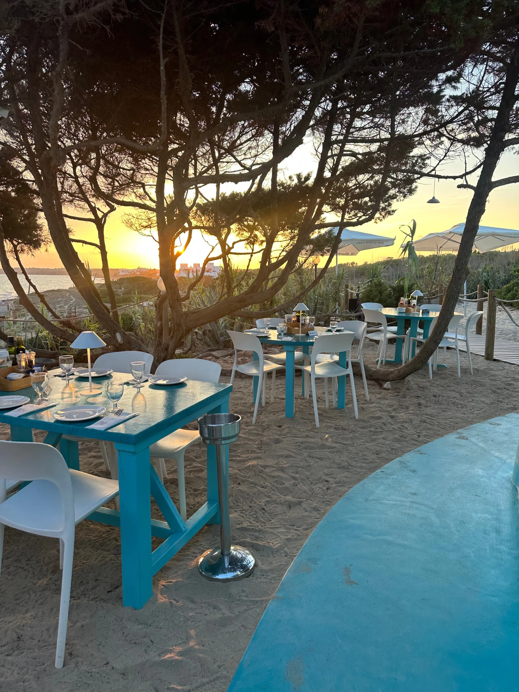 Tables turquoise du Blue Bar sur le sable au coucher du soleil, Migjorn Formentera