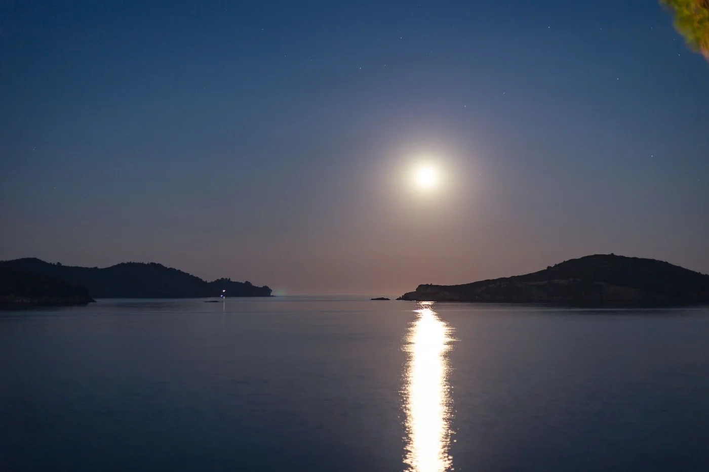 lune basse horizon mer mediterranee Lune basse sur l'horizon marin avec silhouettes de côtes rocheuses
