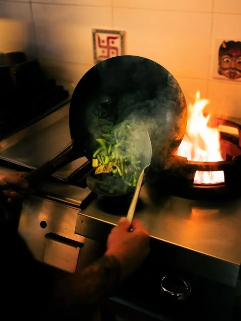 Wok flambé en cuisine au restaurant Supun Ibiza