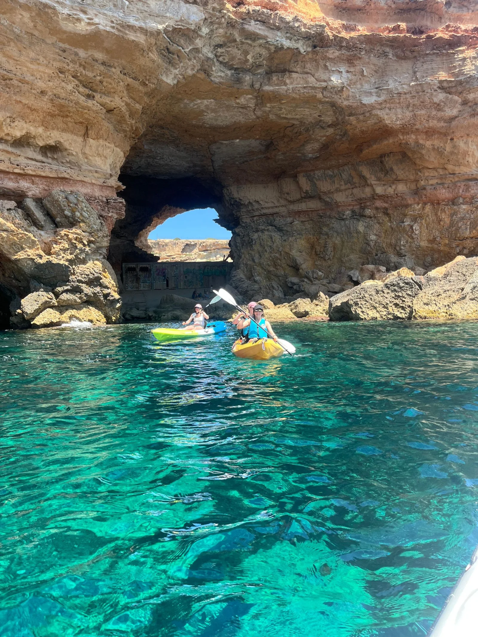 kayak grottes cala codolar 1 Kayaks sous une arche rocheuse près de Cala Codolar