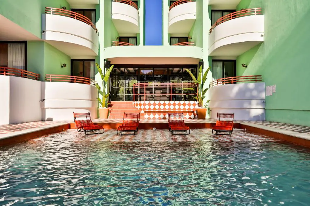 143386753 Piscine au pied de la façade vert d'eau de l'hôtel Cubanito