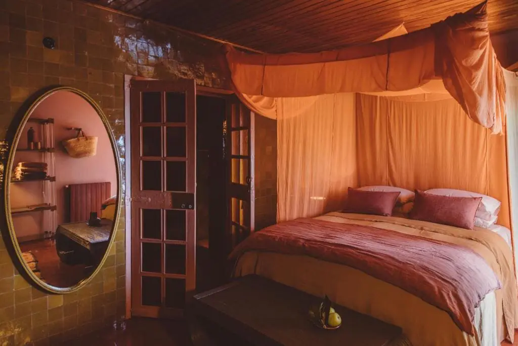 LOS ENAMORADOS IBIZA 2 Chambre aux voilages ocre et miroir rond de l'hôtel Los Enamorados
