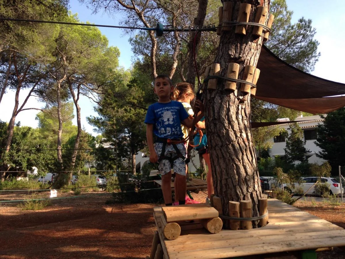 acrobosc ibiza plateforme petits Jeunes enfants équipés de harnais sur une plateforme en bois du parcours vert d'Acrobosc