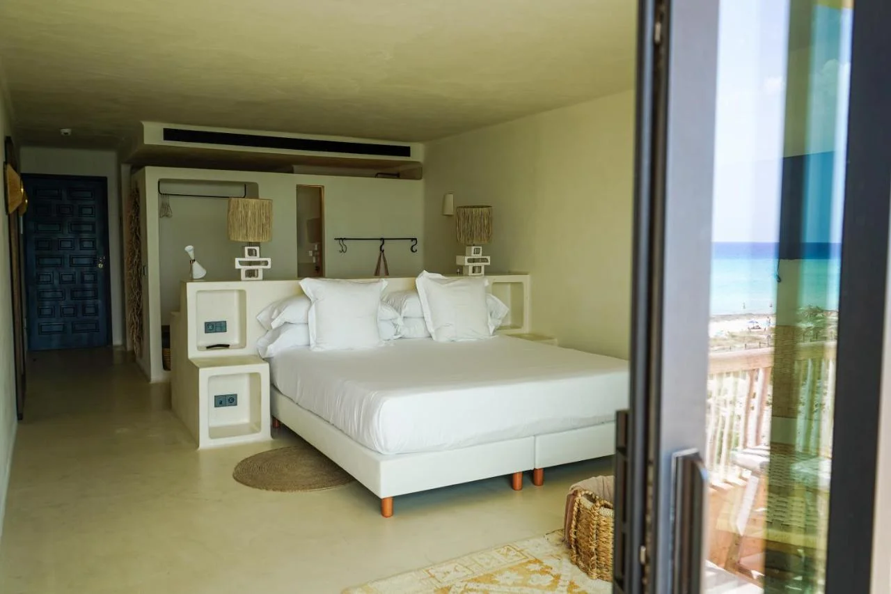 Chambre double du Hannah Formentera, lit blanc et accès au balcon