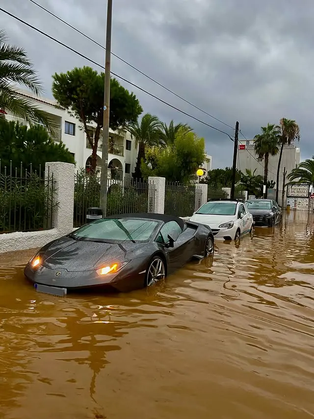 Voiture de sport bloquée dans une rue inondée d'Ibiza pendant la tempête Alice