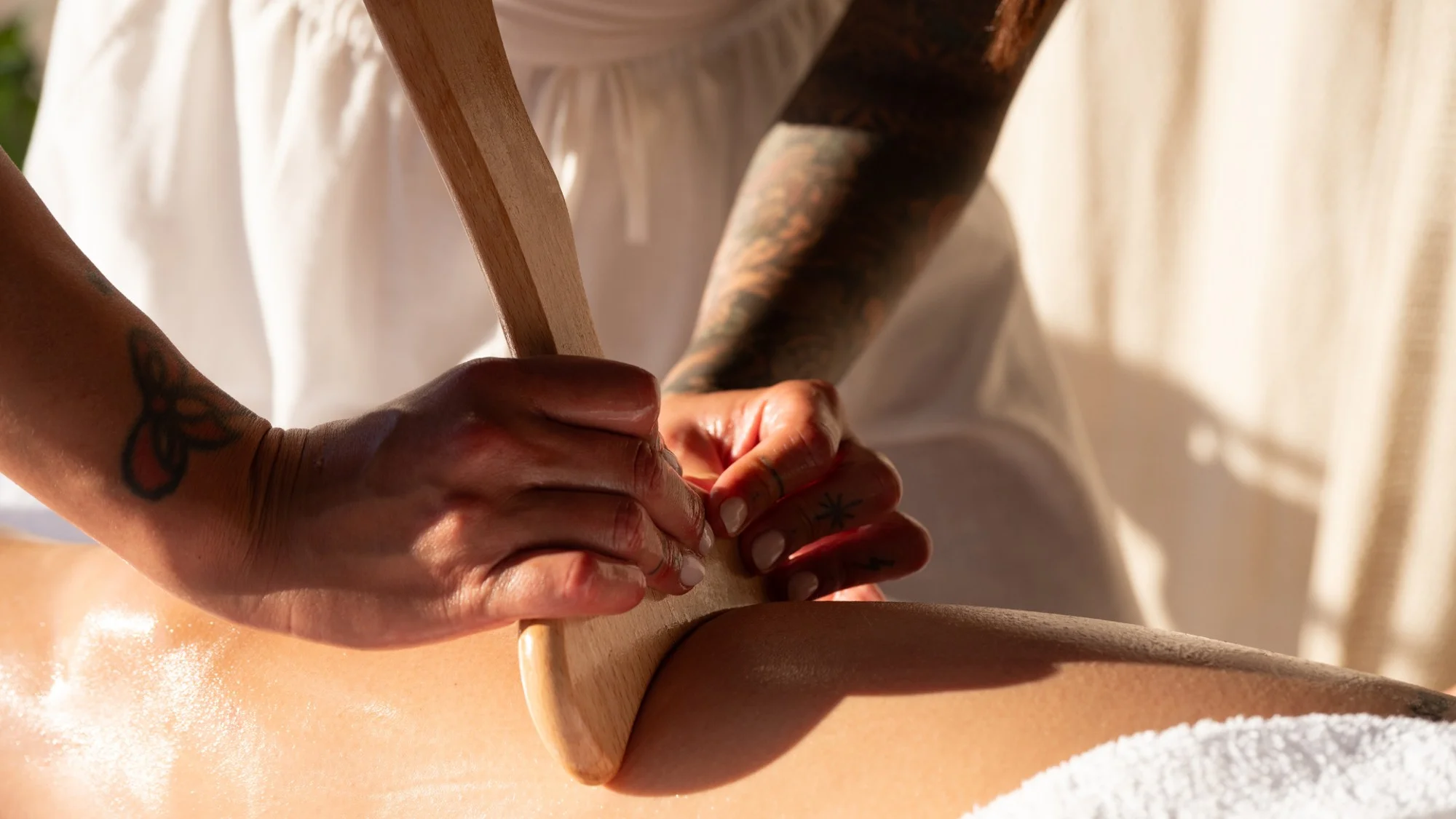 massage rituel bien etre ibiza Gros plan sur les mains d'une masseuse pendant un massage aux outils en bois à Ibiza