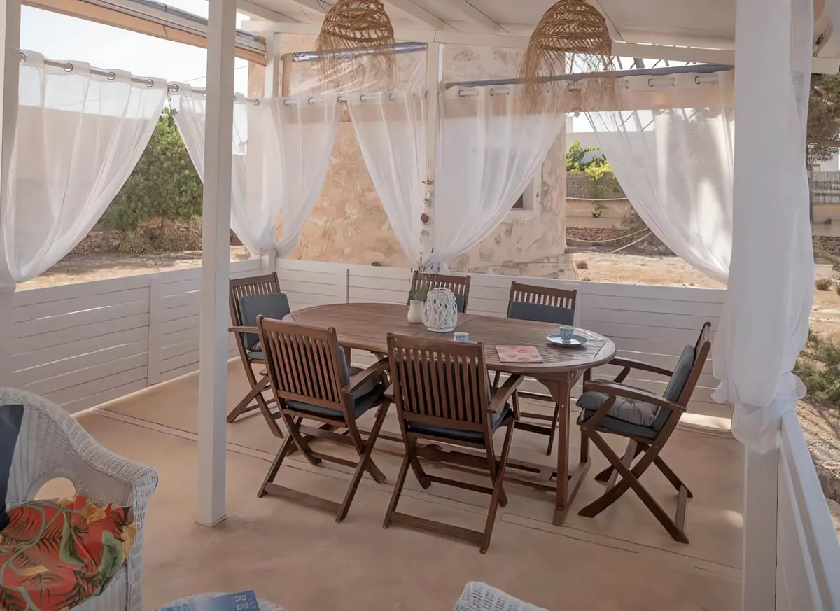 moulin formentera nuit insolite Moli Los Cuatro Soles 2 Table à manger sous une pergola aux voilages blancs, moulin à Formentera
