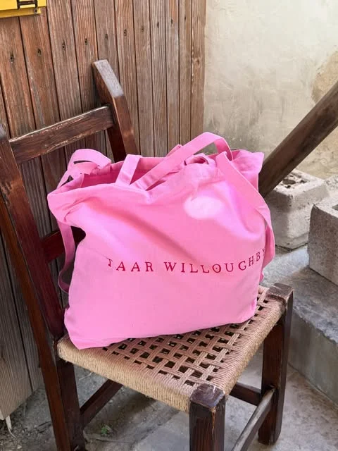 taar willoughby ibiza sac rose Sac cabas rose Taar Willoughby posé sur une chaise en rotin