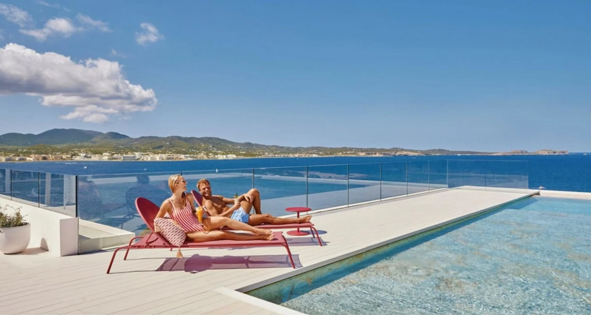 trs ibiza hotel rooftop piscine couple au bord de la piscine rooftop du TRS Ibiza Hotel face à la baie de Sant Antoni